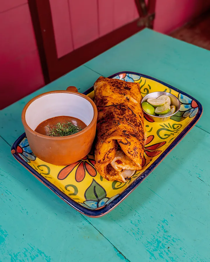 Plato de birria de res con su taza de consomé
