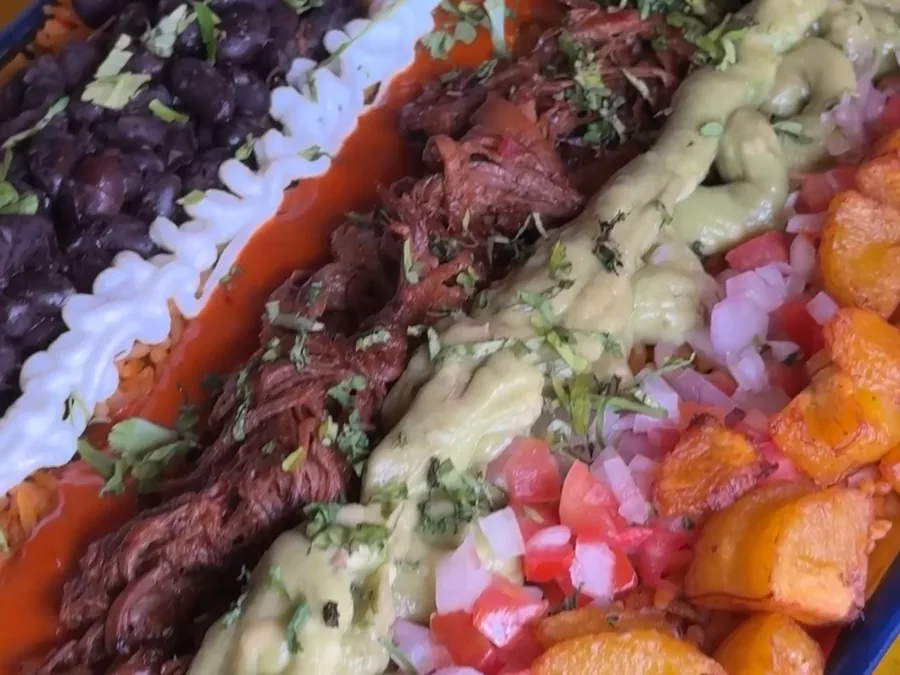 Bowl de birria servido en la mesa amarilla del local