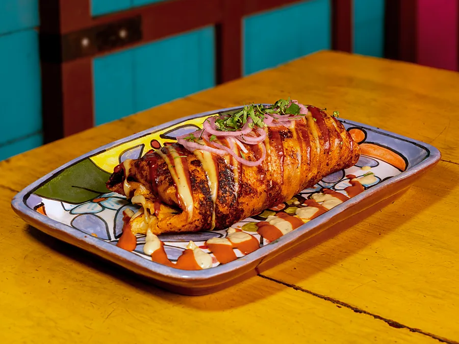 Burrito norteño con salsa taquera, crema y cebolla encurtida