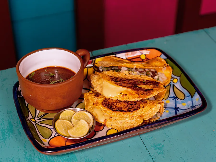 Tacos de birria de res dorados con su taza de consomé