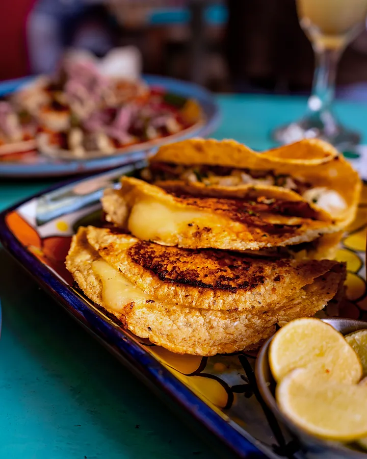 Gringas doradas de queso con limón, servidas en plato de talavera
