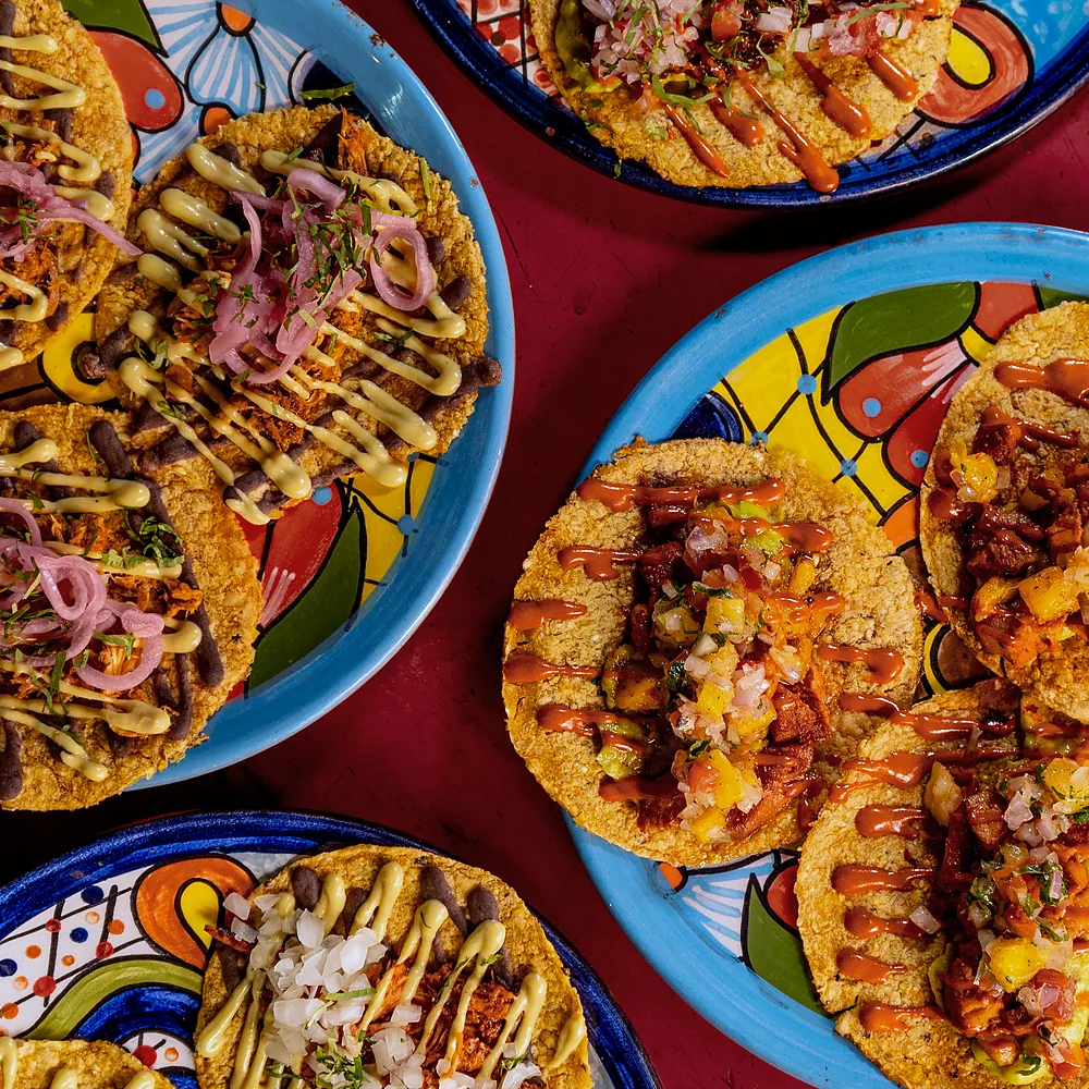 Mesa vista desde arriba con tacos, tostadas y platos de talavera
