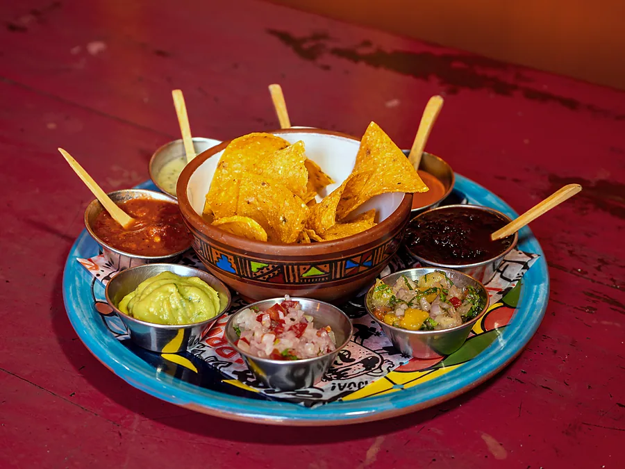 Totopos con guacamole, pico de gallo, frijol y salsas de la casa
